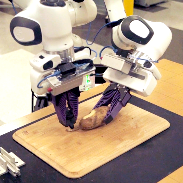 A robot with two prurple hands holds down a potato against a cutting board with one hand while the other peels it