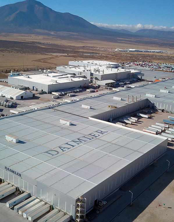 Aerial image showing multiple manufacturing facilities, including a factory for carmaker Daimler at Alianza Industrial Park, with mountains and blue skies in the background