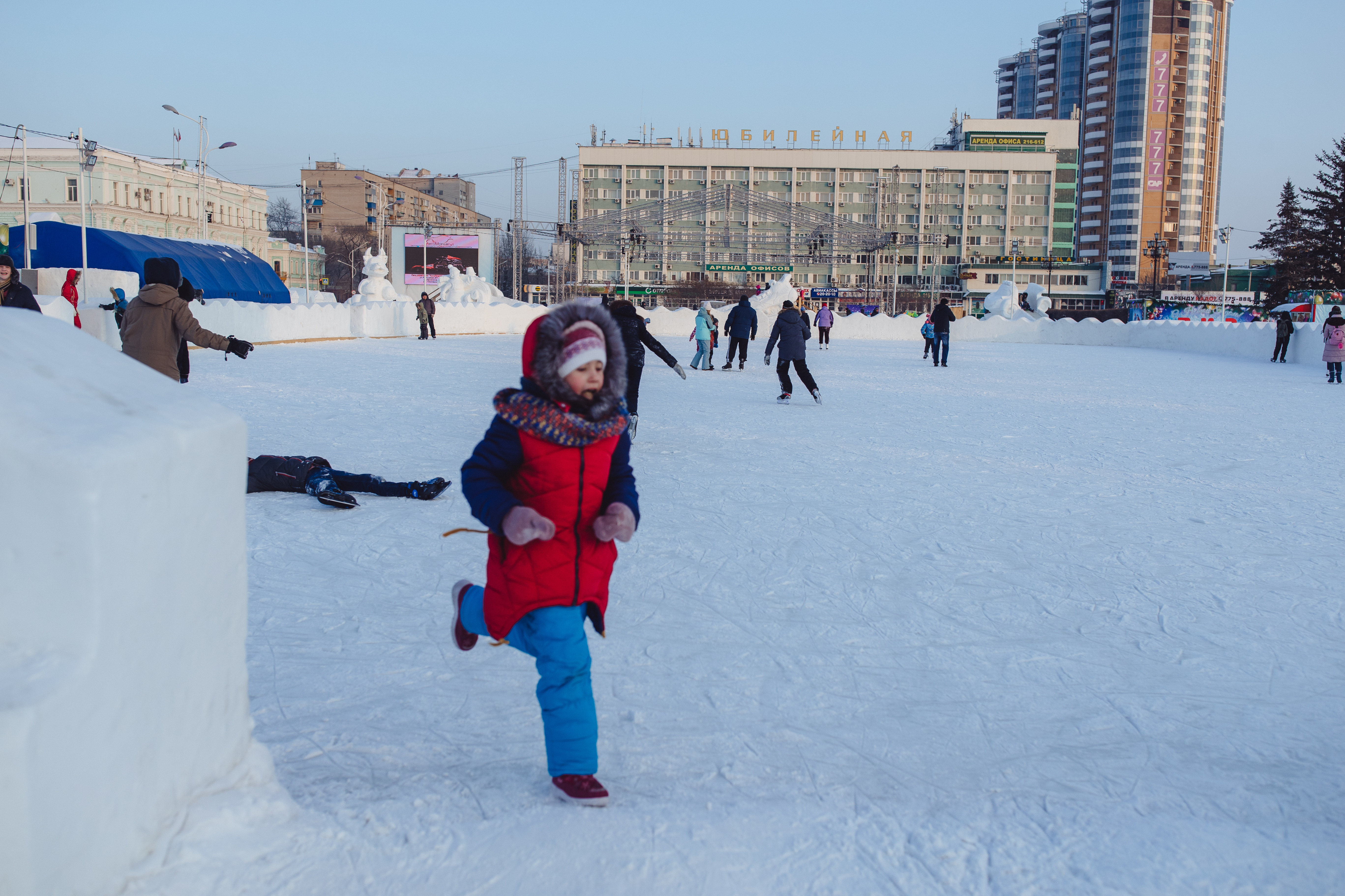 Child running in a snowy square in Blagoveshchensk Russia