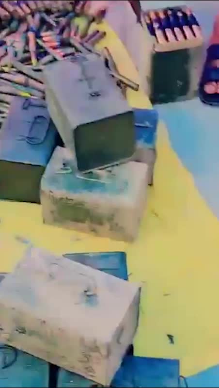 A collection of blue ammunition canisters spread across a yellow floor.