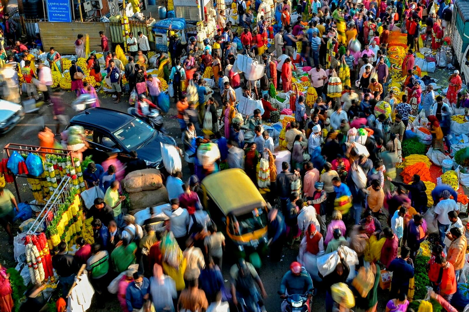 People walk through a market in Bengaluru