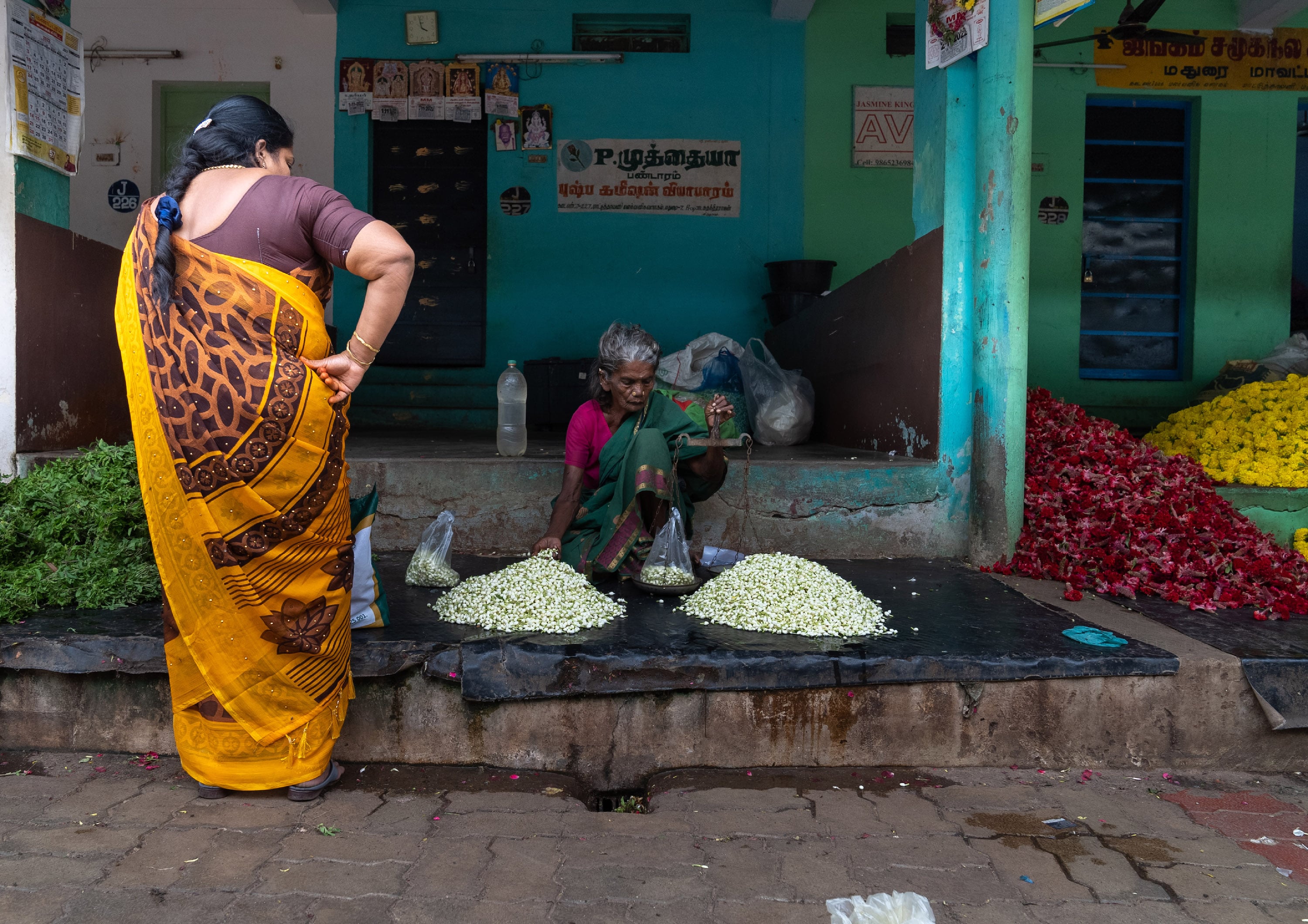 A woman buying flowers at a street market in Tamil Nadu