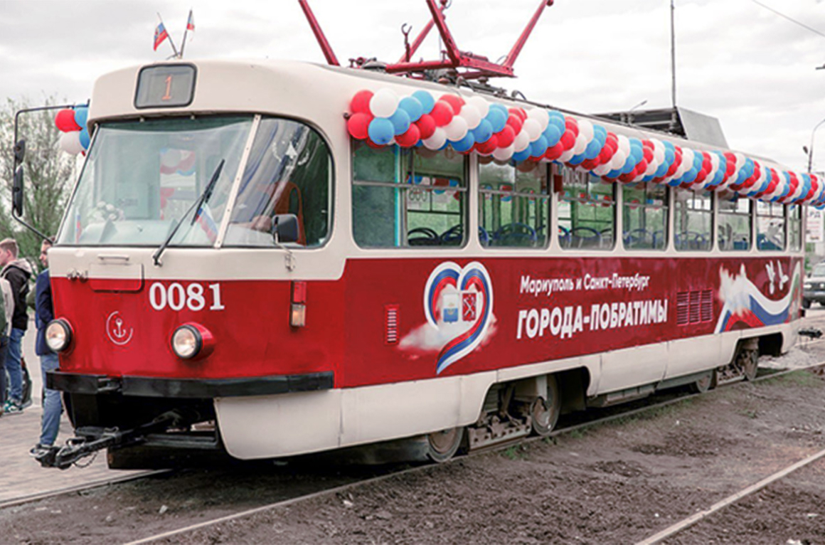 A similar white-and-red streetcar, decorated with white, blue and red balloons and painted with a heart and cyrillic letters along the side.