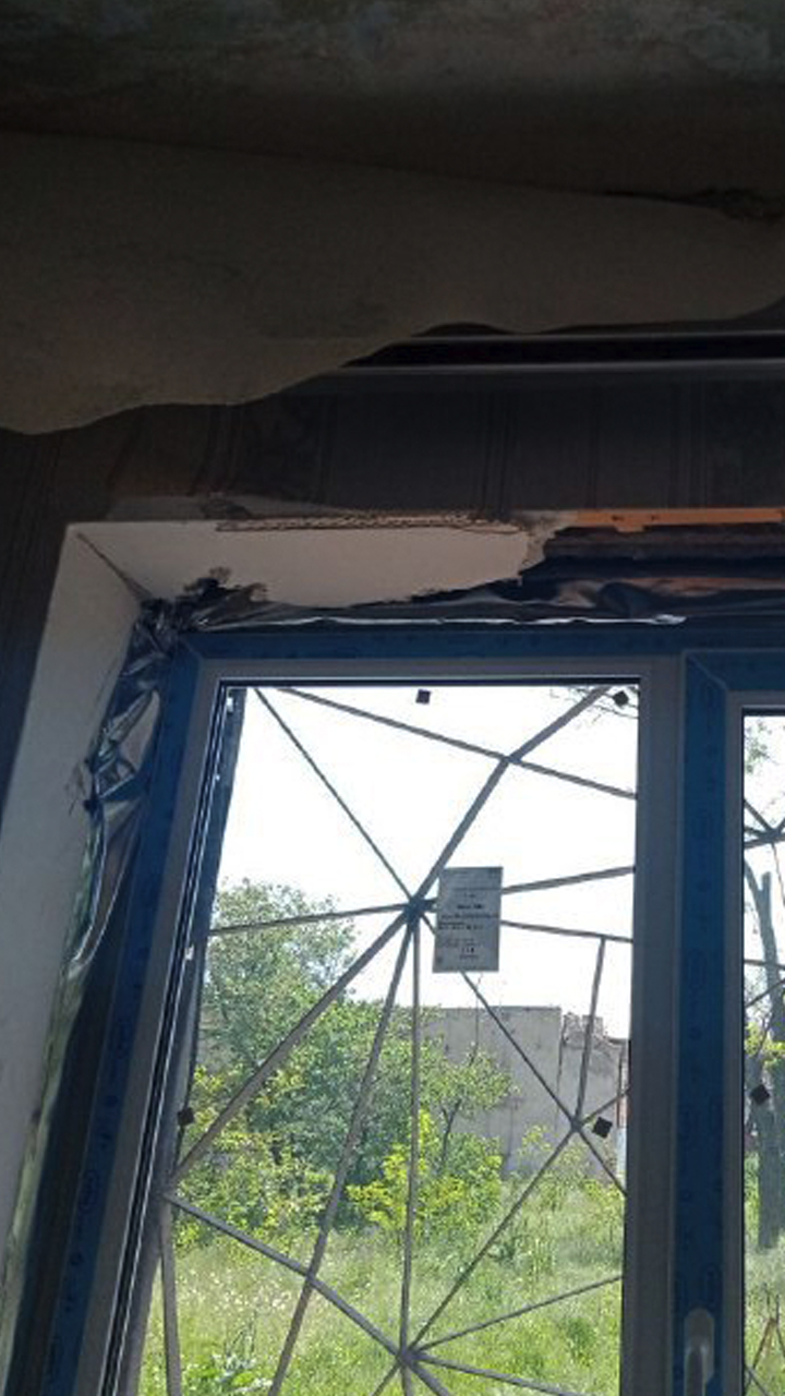 Still image from a video inside an apartment, showing a hastily-installed, poorly-fitted window