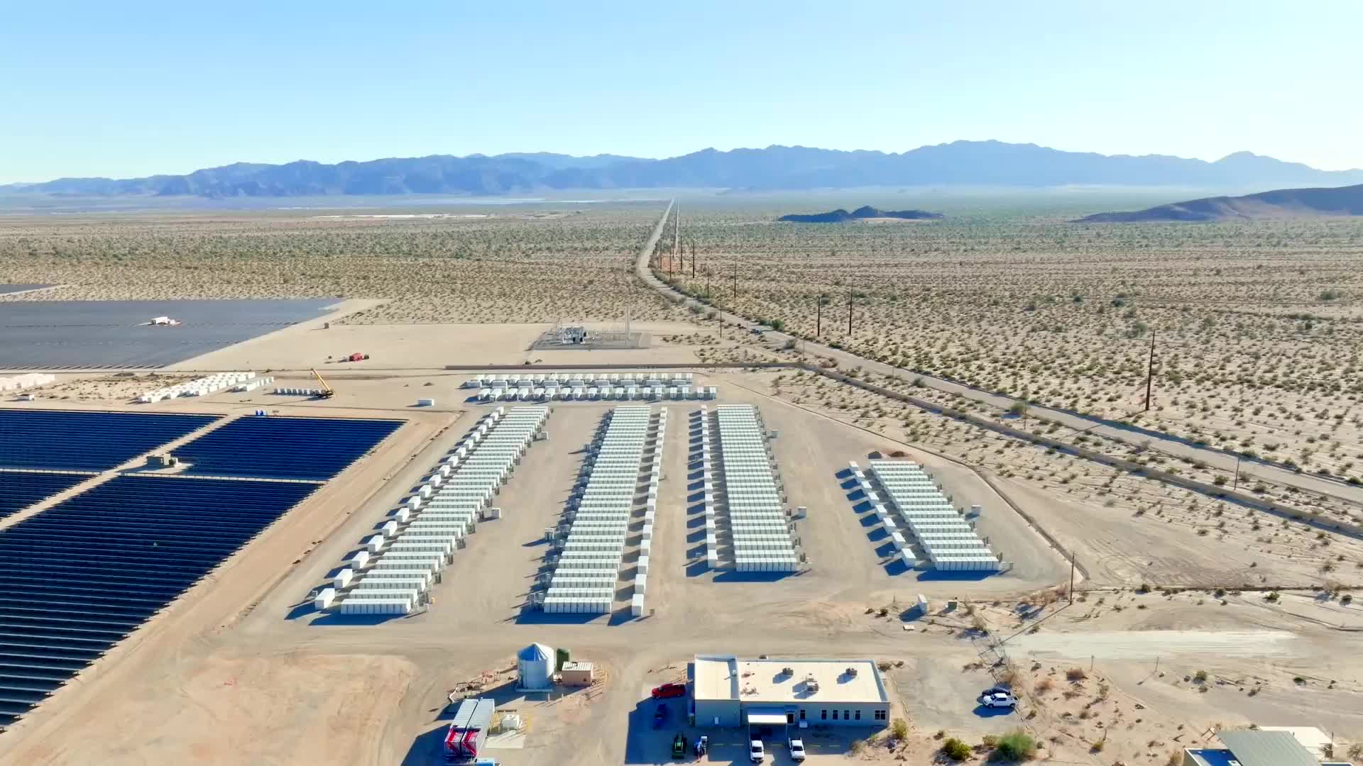 Aerial view of the Edwards Sanborn battery facility in California. Many dozen or hundred very large batteries, resembling shipping containers are visible.