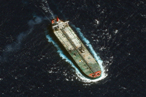 A US military helicopter hovers above the red deck of the Veronica III