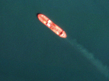 Three satellite images show the Tasca oil tanker at sea on three dates, with its hull colour and markings appearing to change over time.