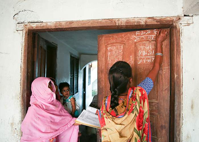 After she has delivered the medication, Urmila marks the door of each house with white chalk