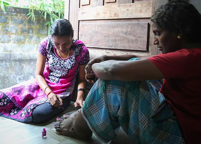 Shobha&#39;s niece Ammu paints her toenails in the doorway of the family home