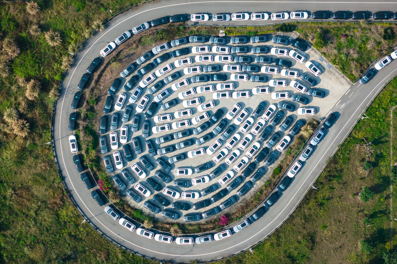 Aerial image of dozens of parked white and grey electric cars circling around a distribution centre in China’s Chongqing municipality